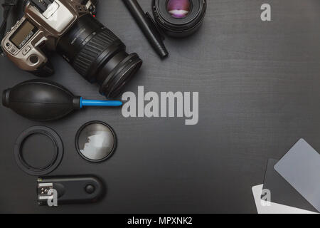 top view of work space photographer with dslr camera system, camera cleaning kit and camera accessory on black table background with copy space Stock Photo