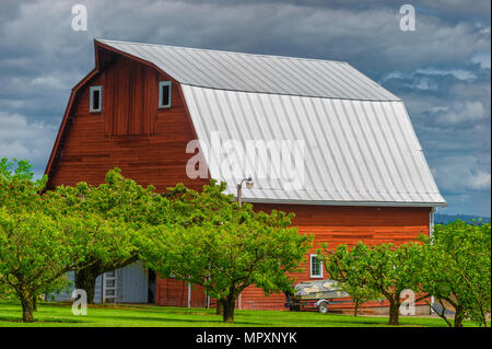 Beaverton,Oregon,USA - May 9, 2018:  Country scene with a Red barn under cloudy skies. Stock Photo