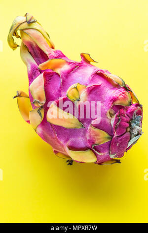Whole dragon fruit (pitaya) close-up on yellow background Stock Photo