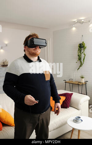 Man looking through virtual reality simulator at home Stock Photo