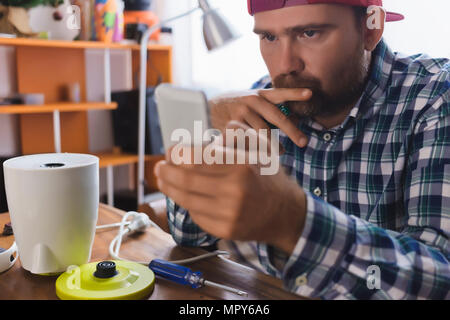 Serious man using smart phone at home Stock Photo