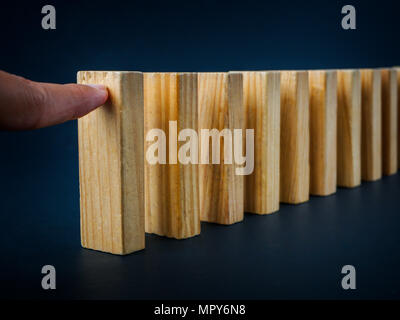 Concept of building success foundation. Chain Reaction In Business Concept, Businessman Letting Or Preventing Dominoes Continuous Toppling On Rustic W Stock Photo