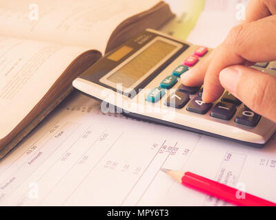 Closed up woman hand using calculator with office accessories on white background. Stock Photo