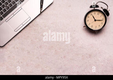 computer laptop with black clock on working table flat lay composition top view  with copy space Stock Photo