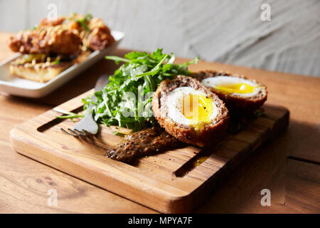 High angle view of scotch eggs with arugula served on serving board Stock Photo