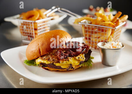 Close-up of cheeseburger with French fries served in plate on table Stock Photo