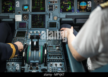 Pilot's hand accelerating on the throttle in  a commercial airliner airplane flight cockpit during takeoff Stock Photo