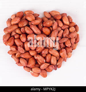 Peanuts in heart symbol isolated on white Stock Photo