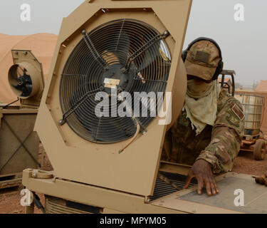 Staff Sgt. Julian Johnson, 768th Expeditionary Air Base Squadron NCO in charge of Heating Ventilation and Air Conditioning, opens the top of an HVAC unit at Nigerien Air Base 101, Niger, April 3, 2017. While cleaning the units, HVAC members spray the inside and outside of units, pull out and clean the air filters, and perform a systems check once finished. (U.S. Air Force photo by Senior Airman Jimmie D. Pike) Stock Photo