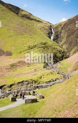 A group of visitors at the viewpoint beneath The Grey Mare's Tail or Roaring Linn waterfall, near Moffat, Dumfries & Galloway, Scotland, UK Stock Photo