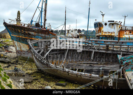 Crumbling ships with flaking paint and rotting structures in the boat graveyard at Camaret-sur-Mer in the Finistere region of Brittany, France. Stock Photo