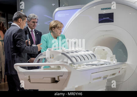 25 May 2018, China, Shenzhen: German Chancellor Angela Merkel of the Christian Democratic Union (CDU) takes a tour of the company Siemens Shenzhen Magnetic Resonance LTD, alongside Siemens CEO Joe Kaeser (c). The company's general manager Pan Huaiyu (l) shows his visitors an MRI scanner. Merkel is in China for a two-day state visit. Photo: Michael Kappeler/dpa Stock Photo