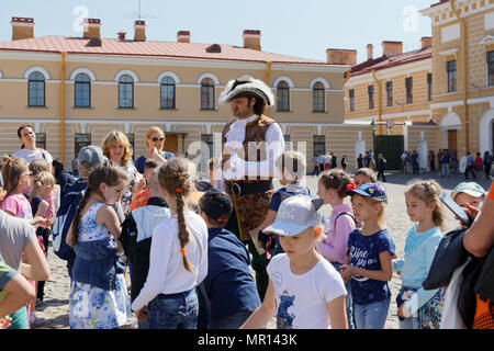 St. Petersburg, Russia, 25th May, 2018. Children make photos with an actor in image of Peter the Great at the St. Peter and Paul Cathedral in the first day of school vacation Stock Photo