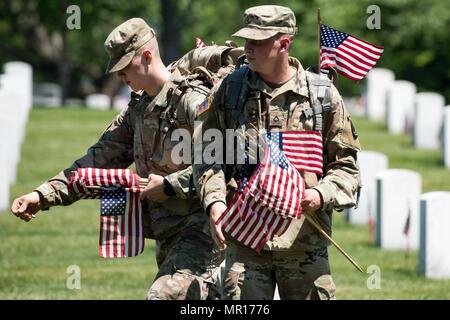 Virginia, USA, 25 May 2018. U.S. soldiers from the 3d Infantry Regiment place American flags at the headstones during Flags In at Arlington National Cemetery to mark Memorial Day May 24, 2018 in Arlington, Virginia. In the 60-year-old tradition more than 1,000 Soldiers placed 234,537 flags in front of every headstone and Columbarium and niche wall column in the cemetery. Credit: Planetpix/Alamy Live News Stock Photo