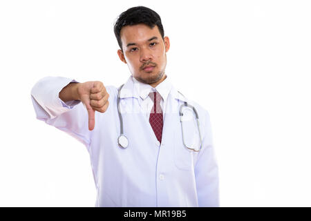 Studio shot of young Asian man doctor giving thumb down Stock Photo