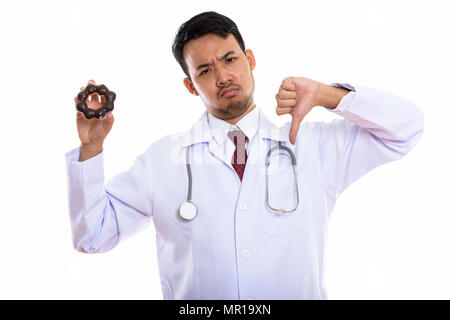 Studio shot of young Asian man doctor holding donut and giving t Stock Photo