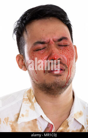 Face of young crazy Asian man looking sad with eyes closed and b Stock Photo