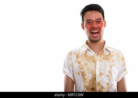 Studio shot of young happy crazy Asian man smiling and laughing  Stock Photo