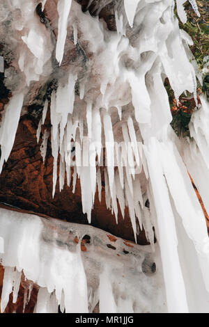 Red rocks are ice covered along the shoreline of the Apostle Islands National Lakeshore, Bayfield, Wisconsin, USA Stock Photo