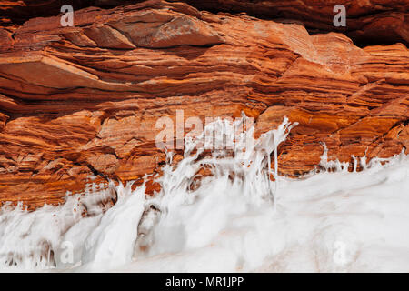 Red rocks are ice covered along the shoreline of the Apostle Islands National Lakeshore, Bayfield, Wisconsin, USA Stock Photo