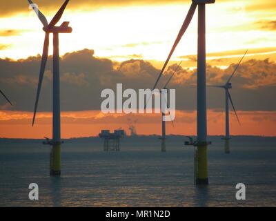 Out Newton wind farm off the Holderness coast viewed from cargo ship entering the Humber Estuary as the sun sets over Holderness Stock Photo