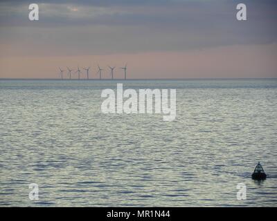 Out Newton wind farm off the Holderness coast viewed from cargo ship entering the Humber Estuary as the sun sets over Holderness Stock Photo