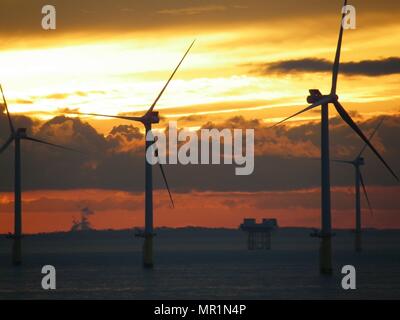 Out Newton wind farm off the Holderness coast viewed from cargo ship entering the Humber Estuary as the sun sets over Holderness Stock Photo