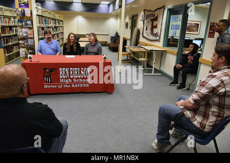 Emily Donovan, daughter of Senior Master Sgt. Rebecca Donovan, 168th Force Development superintendent, Alaska Air National Guard, answers questions from Devin Fry, sports anchor from Fairbanks’ CBS affiliate, and Danny Martin, sports editor of Fairbanks Daily News-Miner, inside the Ben Eielson High School library, April 27, 2017, Eielson AFB, Alaska. Donovan, will be playing college volleyball in Tennessee and will study exercise science and sports psychology. (U.S. Air National Guard photo by Senior Master Sgt. Paul Mann/Released) Stock Photo