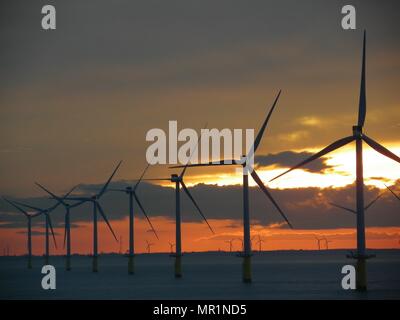 Out Newton wind farm off the Holderness coast viewed from cargo ship entering the Humber Estuary as the sun sets over Holderness Stock Photo