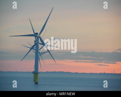 Out Newton wind farm off the Holderness coast viewed from cargo ship entering the Humber Estuary as the sun sets over Holderness Stock Photo