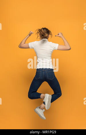 Closeup of young woman's body in empty white t-shirt on orange background. Mock up for disign concept Stock Photo