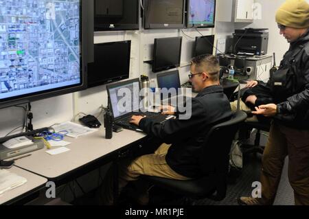 63rd Civil Support Team is a unit of the Oklahoma Army National Guard trained to respond to chemical, biological, radiological, nuclear, and high-yield explosive incidents. This archival photograph documents CST personnel maintaining a common operating picture in an operations trailer during the Oklahoma City Memorial Marathon in downtown Oklahoma City. The historical photographic print records interagency coordination for public safety. Stock Photo
