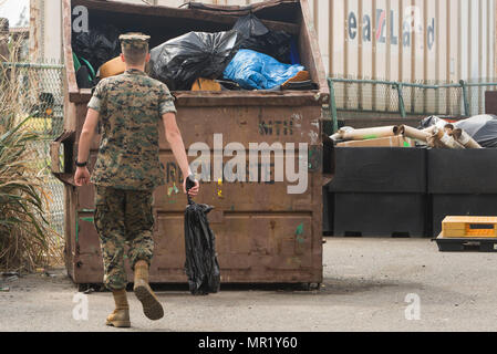 Pfc. Michael Powell, an artillery mechanic with Combat Logistics Battalion 3, throws away trash during a base wide cleanup at the recycling center aboard Marine Corps Base Hawaii on April 20, 2017. The semiannual cleanup event, “Malama Ka Aina,” is dedicated to cleaning MCB Hawaii, Pu’uola Rifle Range, Marine Corps Training Area Bellows, and Camp Smith. Malama Ka Aina is Hawaiian for “care for the land,” where Marines and Sailors from various units aboard MCB Hawaii work together to help keep each military installation litter free. (U.S. Marine Corps photo by Lance Cpl. Isabelo Tabanguil)