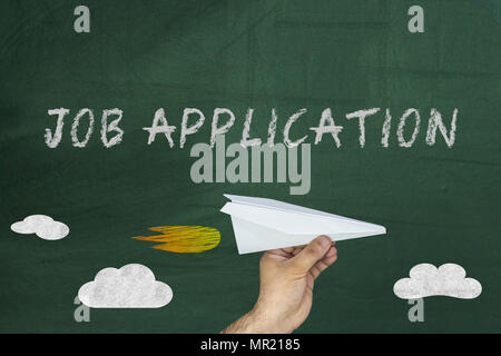 Job application words on blackboard. Hand holding paper plane Stock Photo