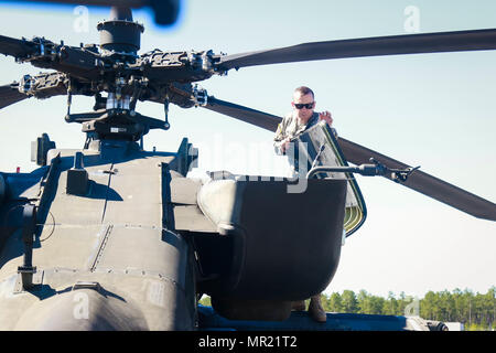 Chief Warrant Officer 2 Sexton assigned to 1st Attack Reconnaissance Battalion, 82nd Combat Aviation Brigade performs preflight checks on an AH-64 Apache helicopter before flight in support of a joint Combined Arms Live Fire Exercise on Fort Bragg, N.C., May 3. (U.S. Army photo by Sgt. Steven Galimore) Stock Photo