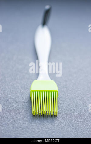 green silicone pastry brush on the blue background Stock Photo