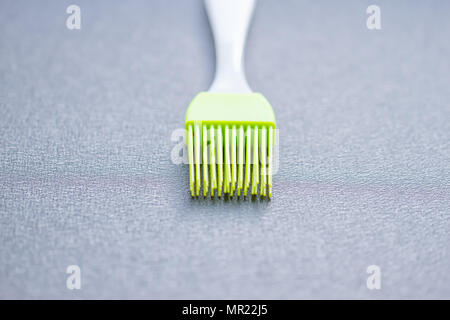green silicone pastry brush on the blue background Stock Photo