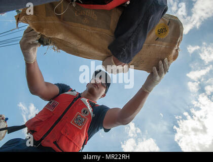 Crew members from Coast Guard Cutter Tarpon, an 87-foot Coast Patrol Boat homeported in St. Petersburg, Florida, offload 1,735 kilograms of cocaine, an estimated wholesale value of $56 million and transfer custody of eight suspected drug smugglers Wednesday, May 3, 2017 at Coast Guard Sector St. Petersburg, Florida. The contraband and suspected smugglers were interdicted during four separate cases supporting Operation Martillo, a joint interagency and multi-national collaborative effort among 14 Western Hemisphere and European nations to stop the flow of illicit cargo by Transnational Criminal Stock Photo