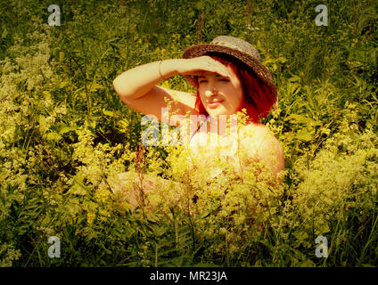 young girl in the summer among wildflowers Stock Photo