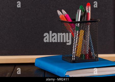 Stationery: pens, pen holder, diary on a black background Stock Photo