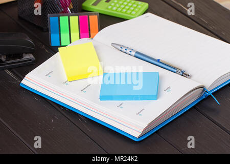 Open diary, pen on a black wooden background Stock Photo