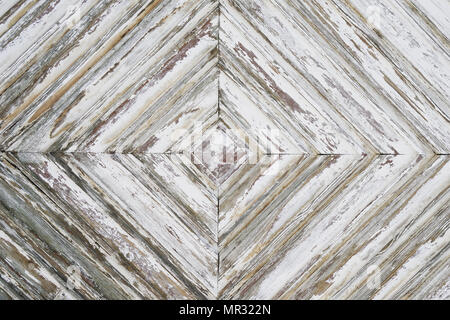 distressed wood paneling background texture pattern, detail of old weathered wooden door with white paint peeling off Stock Photo