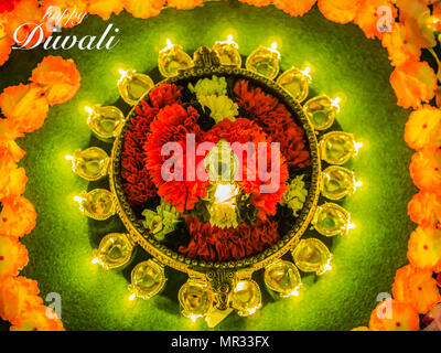 Traditional clay diya lamps lit with flowers for Diwali festival celebration. Stock Photo