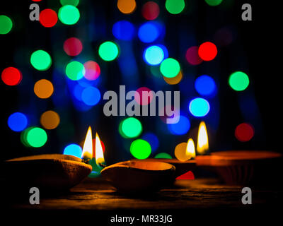 Happy Diwali - Diya lamps lit with bokeh background during diwali celebration. Stock Photo