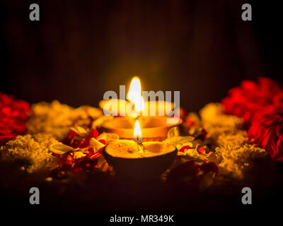 Happy Diwali - Diya lamps lit with flowers during diwali celebration. Stock Photo