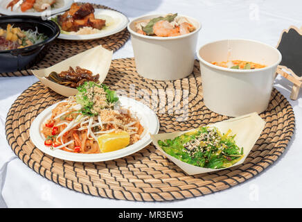 food samples, variations of diverse Asian dishes served on trays during the Asian street farmers market. Soft shell Crab Bao, roasted silkworm, Tom Yu Stock Photo