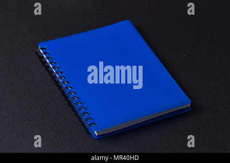 Blue notepad on a spiral on a black background Stock Photo