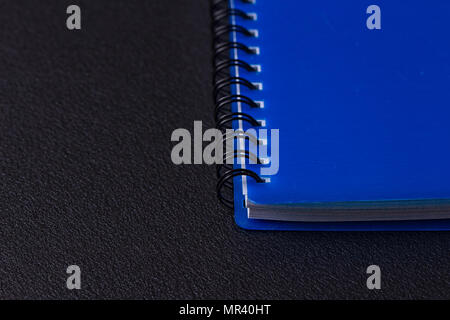 Blue notepad on a spiral on a black background Stock Photo