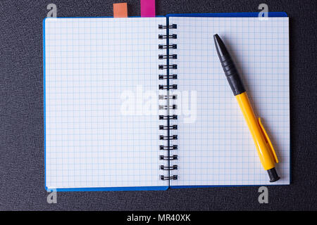 Open notepad on a spiral and pen on a black background Stock Photo