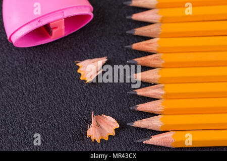 Simple pencils and a pink pencil sharpener on a black background Stock Photo